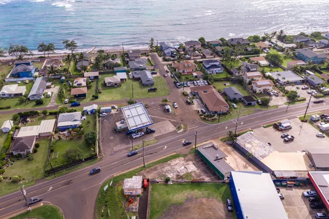 an aerial view of a city with lots of residential buildings ocean and mountain view in back