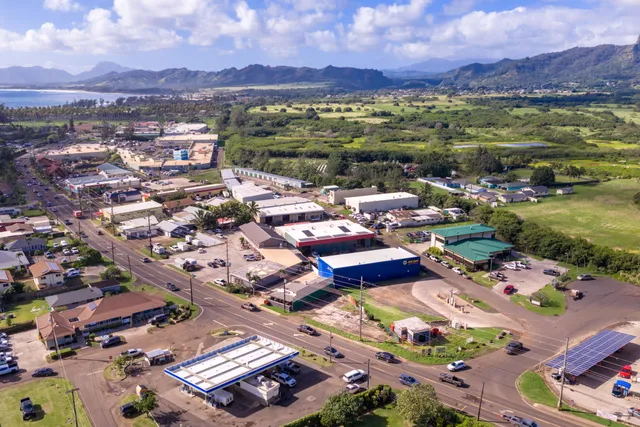 an aerial view of a city with lots of residential buildings ocean and mountain view in back
