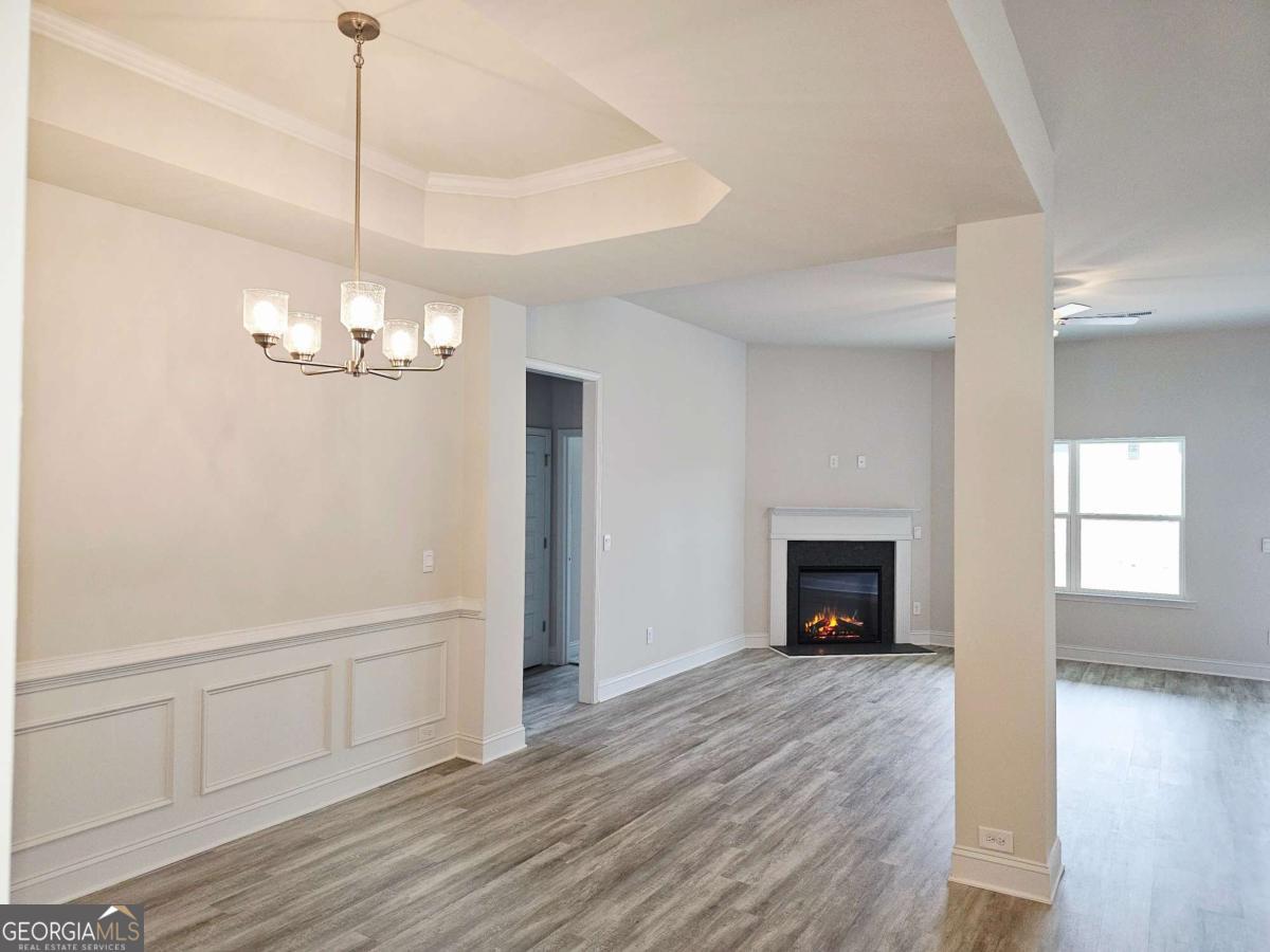 301 Angela Avenue, Unit 8 Bowdon, GA 30108 - Photo 2 of 4 a view of a livingroom with a fireplace wooden floor and chandelier