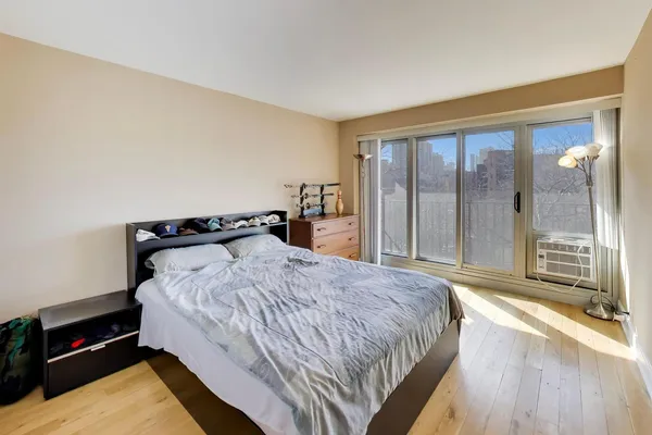 a bedroom with a bed and a large window