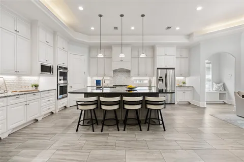 a large kitchen with cabinets table and chairs