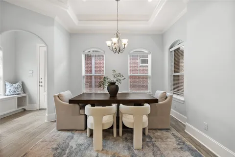 a dining room with furniture a chandelier and wooden floor