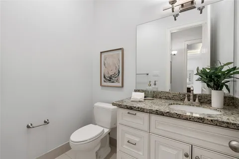 a bathroom with a granite countertop sink mirror vanity and toilet