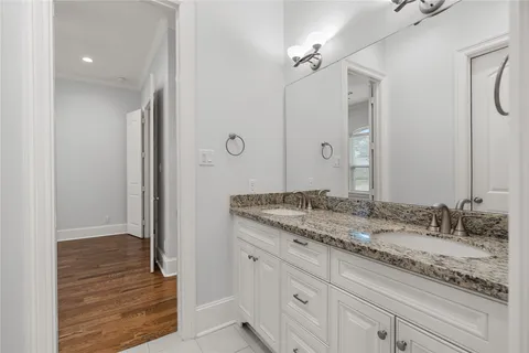 a bathroom with a granite countertop sink a mirror and a shower