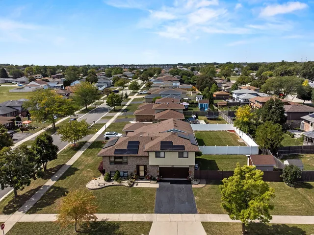 an aerial view of residential houses with outdoor space and ocean view
