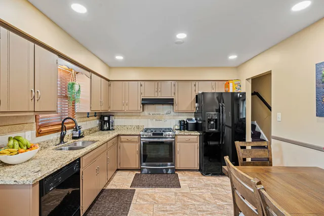 a kitchen with a sink a counter top space stainless steel appliances and cabinets