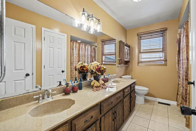 a bathroom with a sink double vanity granite and a mirror