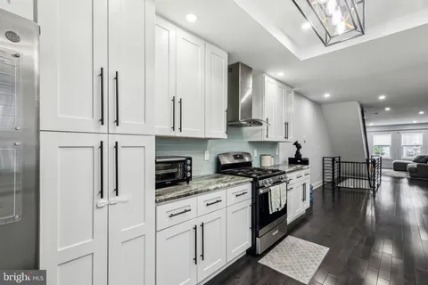 a kitchen with stainless steel appliances granite countertop a stove a sink and a refrigerator