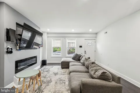 a living room with furniture a flat screen tv and a fireplace