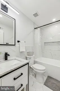 a bathroom with a sink a toilet a mirror and shower
