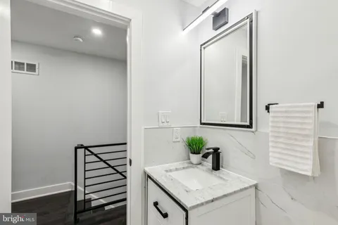 a bathroom with a granite countertop sink and a mirror