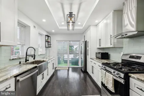 a kitchen with stainless steel appliances granite countertop a sink stove and cabinets