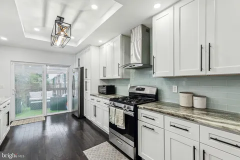 a kitchen with stainless steel appliances granite countertop a stove a refrigerator and a sink