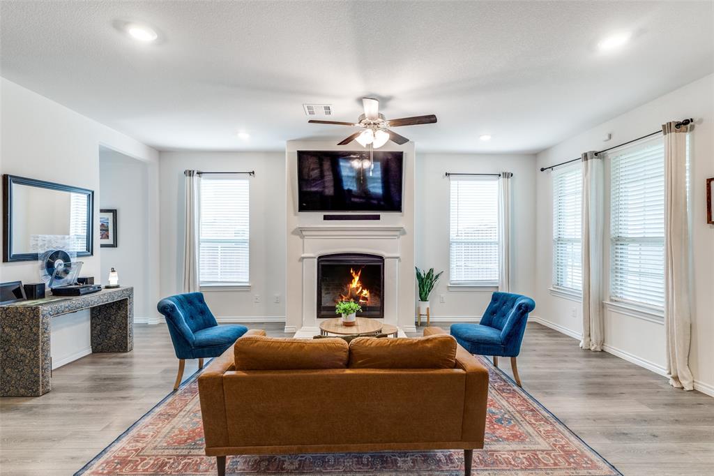 a living room with furniture a flat screen tv and a fireplace