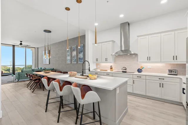 a kitchen that has a lot of cabinets a sink a stove in it and wooden floors