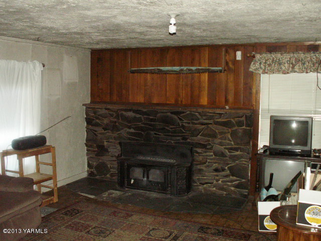 211 Ranger Road Naches, WA 98937 - Photo 6 of 16 a living room with furniture a fireplace and a counter top space