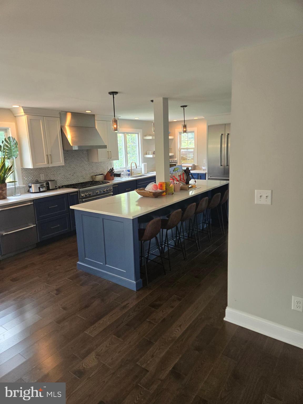 145 East Golf View Road Ardmore, PA 19003 - Photo 58 of 103 a large kitchen with kitchen island a sink dishwasher a stove and a dining table with wooden floor
