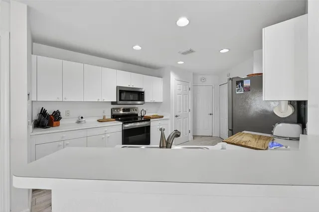 a kitchen that has a lot of cabinets a sink and a couch