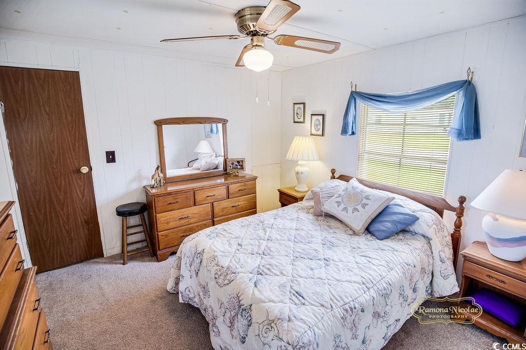 298 Flamingo Surfside Beach, SC 29575 - Photo 13 of 27 Carpeted bedroom with ceiling fan and wooden walls