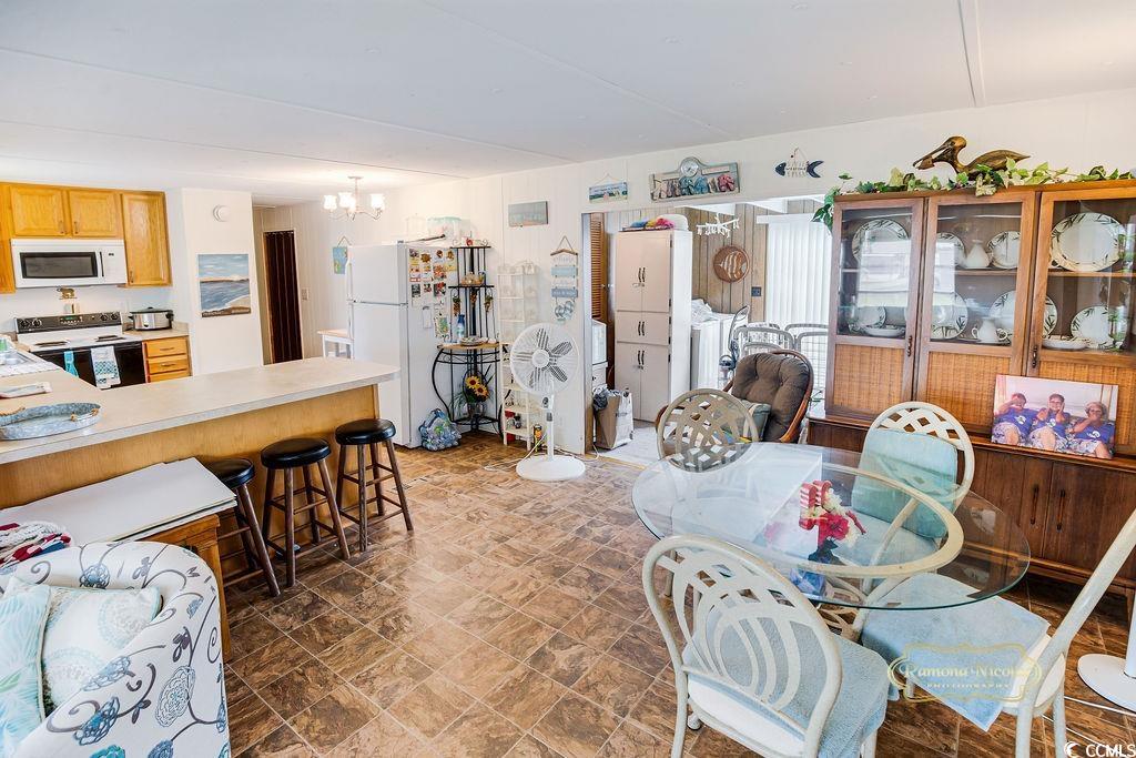 298 Flamingo Surfside Beach, SC 29575 - Photo 18 of 27 Dining room featuring a chandelier and stone finish flooring