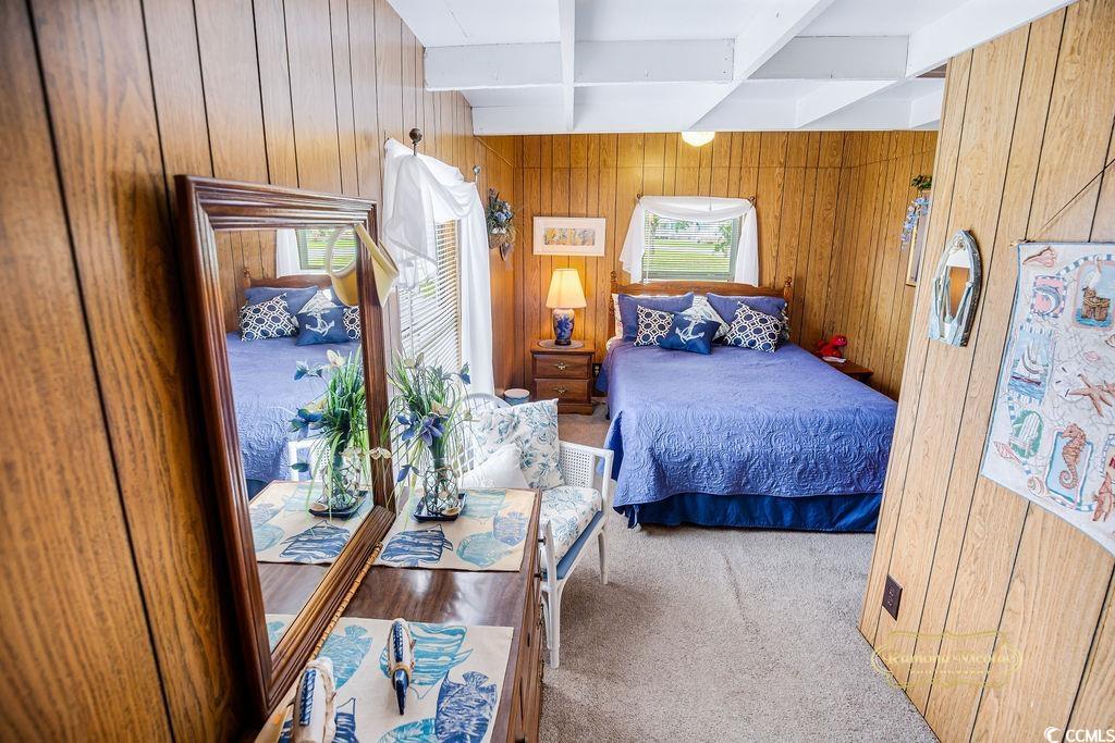 298 Flamingo Surfside Beach, SC 29575 - Photo 25 of 27 Carpeted bedroom featuring beamed ceiling and wooden walls