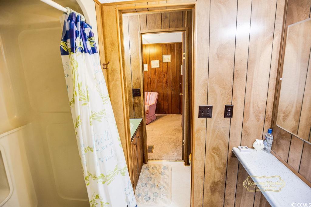 298 Flamingo Surfside Beach, SC 29575 - Photo 6 of 27 Full bath with wooden walls, light tile patterned flooring, and vanity