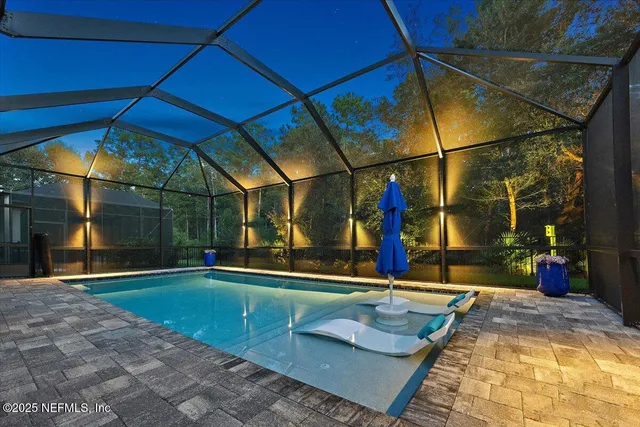 a living room with furniture kitchen view and a chandelier