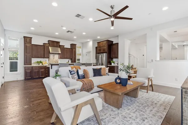 a living room with stainless steel appliances kitchen island granite countertop a couch and a view of kitchen