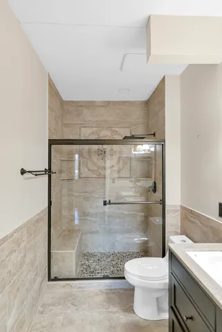 a bathroom with a granite countertop shower a toilet and a sink