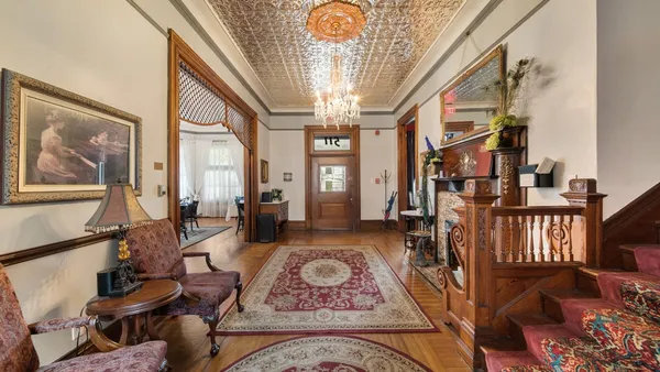 a living room with furniture a chandelier and a large mirror