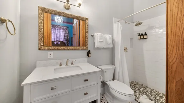 a bathroom with a sink a toilet and shower
