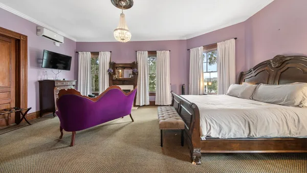 a bedroom with a bed a flat screen tv and dresser