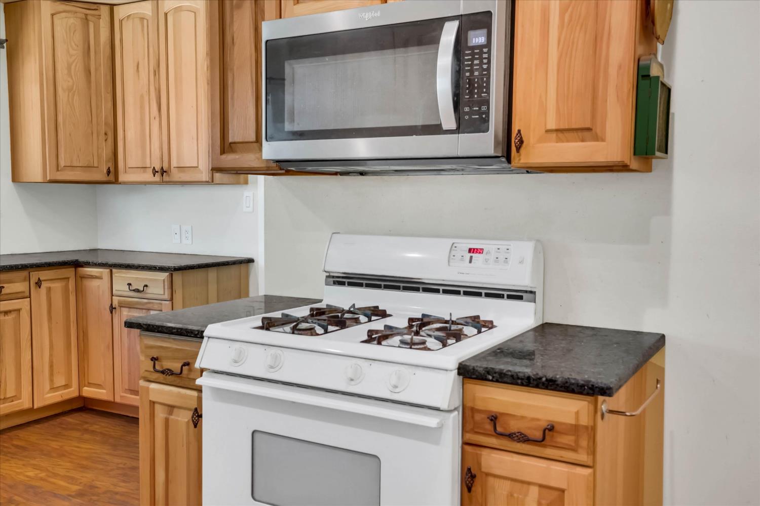 39640 South River Road Clarksburg, CA 95612 - Photo 15 of 25 a kitchen with granite countertop cabinets stove top oven and microwave