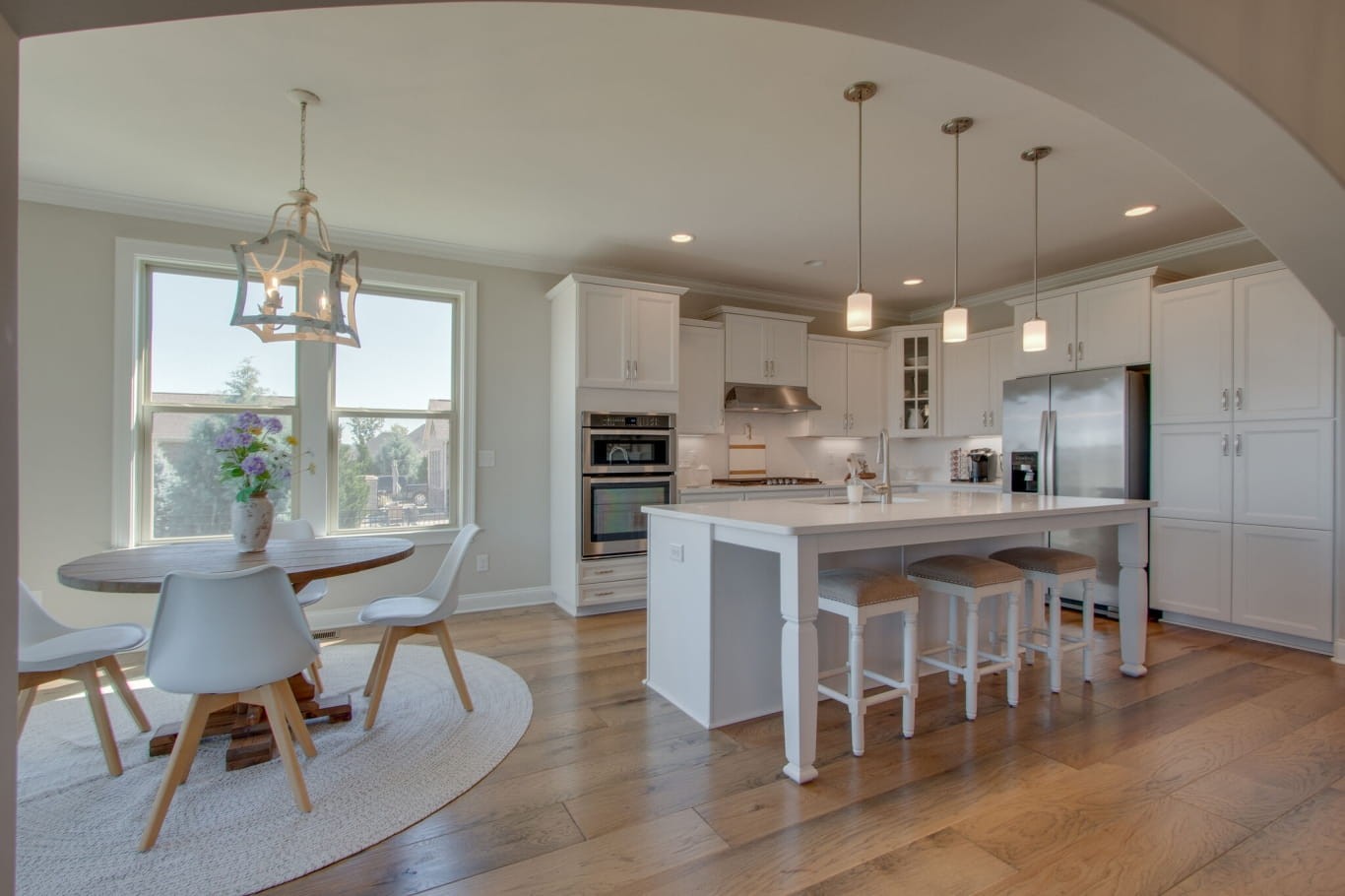 3584 Robbins Nest Road Thompson's Station, TN 37179 - Photo 16 of 43 a kitchen with stainless steel appliances kitchen island granite countertop a dining table chairs and white cabinets