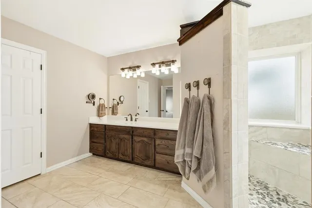 a spacious bathroom with a double vanity sink a mirror and shower