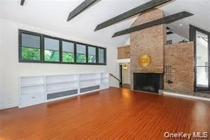 an empty room with wooden floor and fireplace