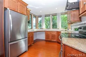 a kitchen with stainless steel appliances granite countertop a refrigerator a sink and a stove
