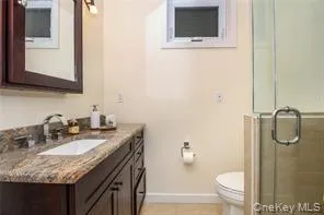 a bathroom with a granite countertop sink toilet and mirror