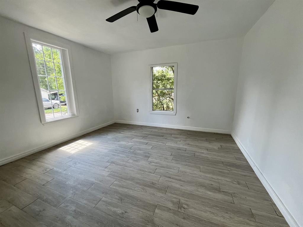 1037 Cedar Street Paris, TX 75460 - Photo 7 of 13 wooden floor in an empty room with a window