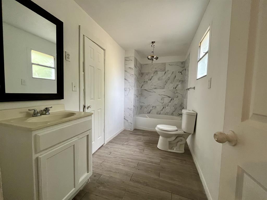 1037 Cedar Street Paris, TX 75460 - Photo 9 of 13 a bathroom with a sink a toilet and shower