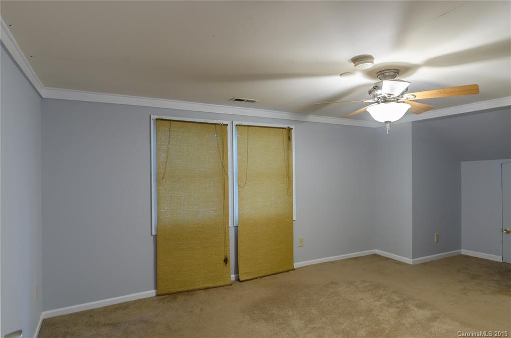2904 Tuckaseegee Road Charlotte, NC 28208 - Photo 13 of 21 an empty room with a chandelier fan and a window