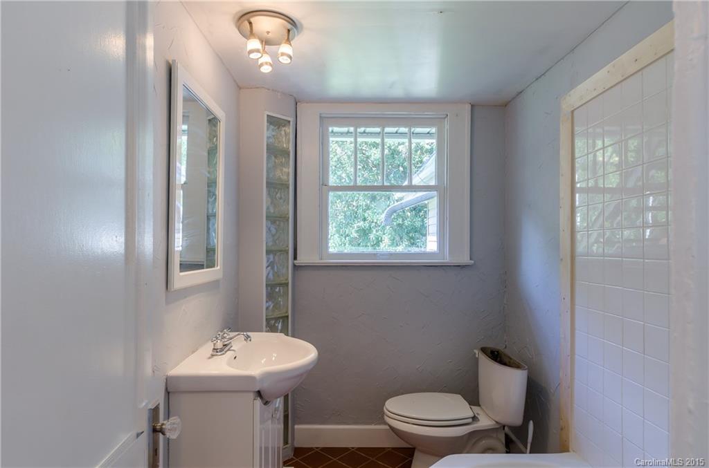2904 Tuckaseegee Road Charlotte, NC 28208 - Photo 8 of 21 a bathroom with a toilet a sink and mirror