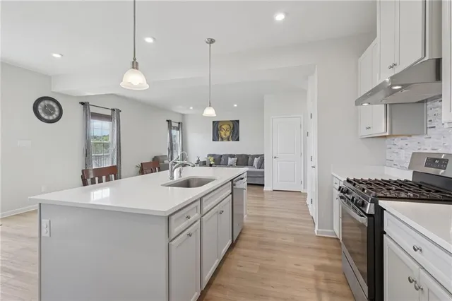 a kitchen with a sink stove and cabinets