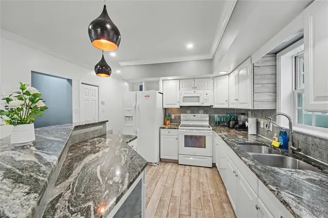a kitchen with granite countertop a sink stainless steel appliances and cabinets