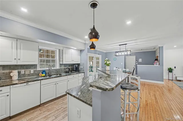 a kitchen with sink a counter top space and living room view