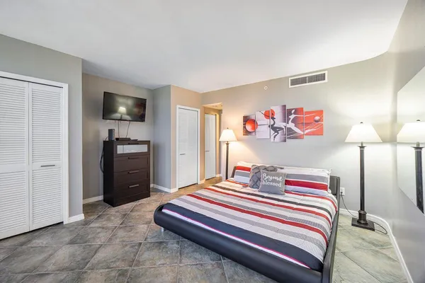 a bedroom with a bed and a flat screen tv