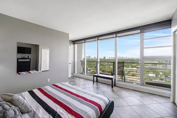 a bedroom with a bed and a large window