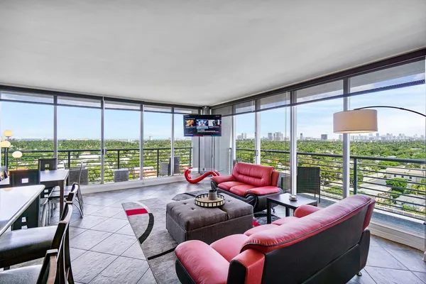 a living room with furniture and floor to ceiling windows