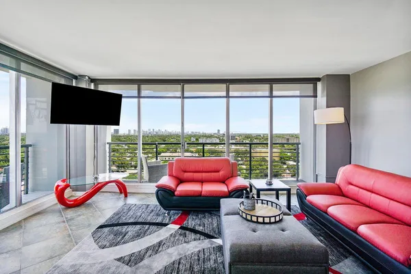 a living room with furniture and a floor to ceiling window
