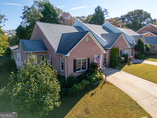 a aerial view of a house with a yard plants and large tree